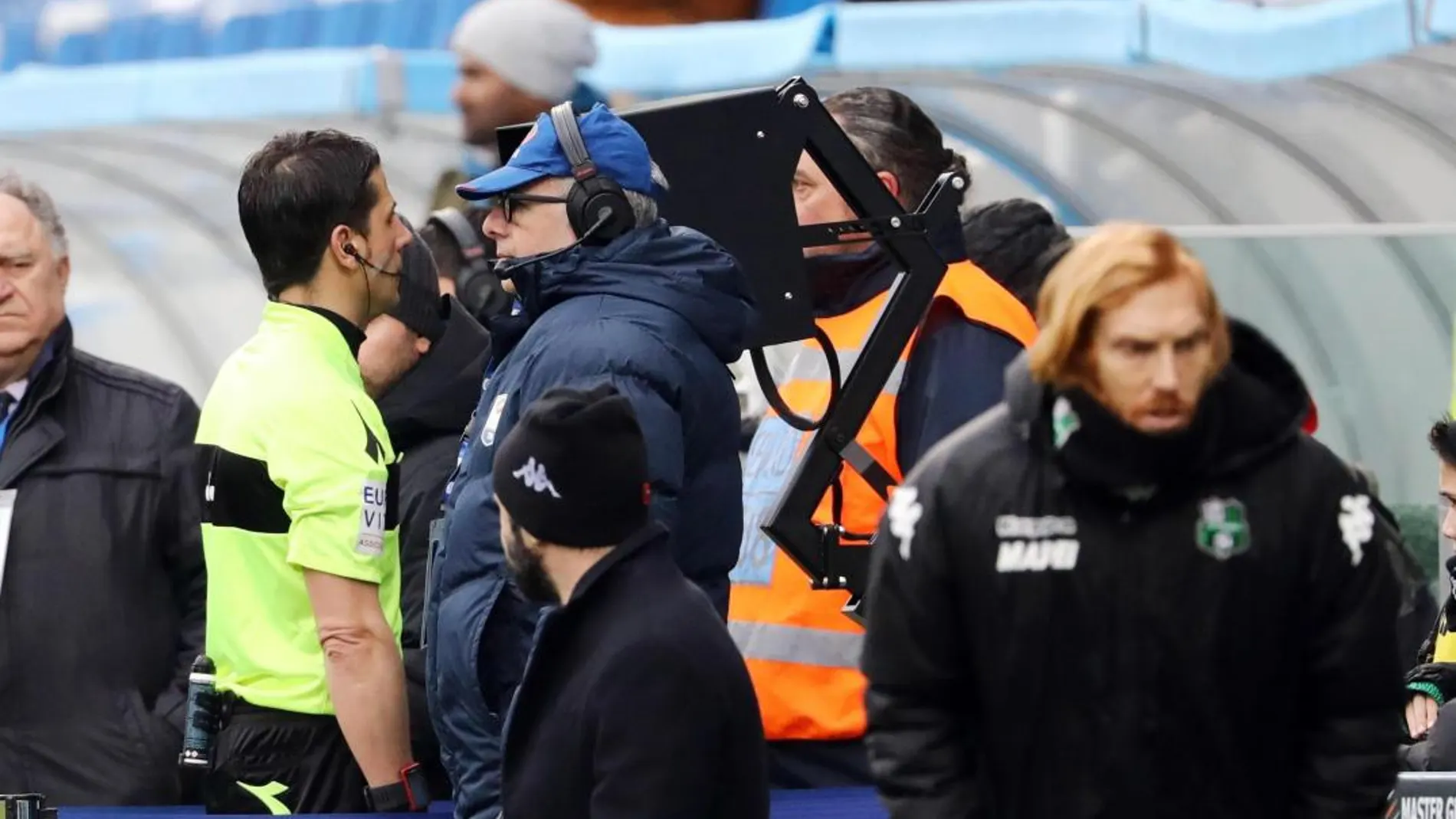 Un árbitro italiano revisa una jugada durante un partido de la Serie A