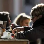 Una mujer disfruta de una bebida caliente durante la mañana de hoy cuando las temperaturas mínimas de la pasada madrugada han sufrido un descenso de entre tres y diez grados sobre las de ayer en varios puntos de la Comunitat Valenciana