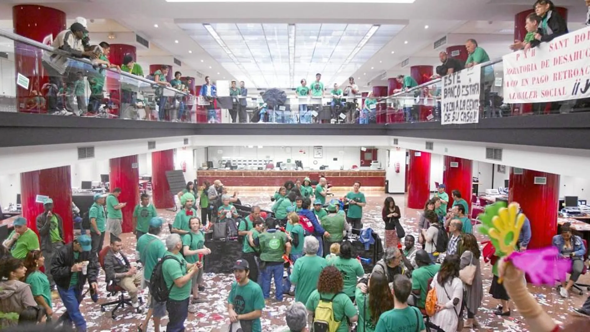 Los activistas de la Plataforma de Afectados por la Hipoteca colgaron pancartas y llenaron de panfletos el suelo de las oficinas centrales del Banco Popular en Barcelona, ayer