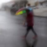 Un viandante, visto a través de un cristal, cruzando una calle en Espartinas (Sevilla)
