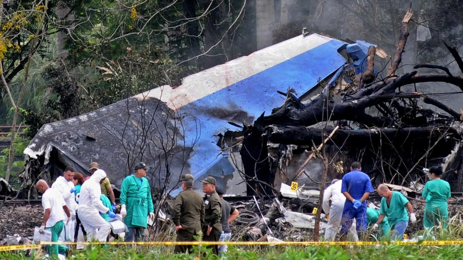 Policías y militares trabajan entre los restos del avión Boeing-737 que se estrelló el pasado viernes/ Efe