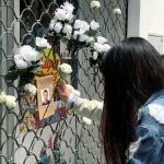 Una mujer coloca una flor ante la foto del ciudadano chino asesinado anoche en Carmona (Sevilla) / Foto: Efe