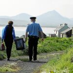 Dos funcionarios transportan una urna en la isla irlandesa de Inishbofin un día antes del referéndum