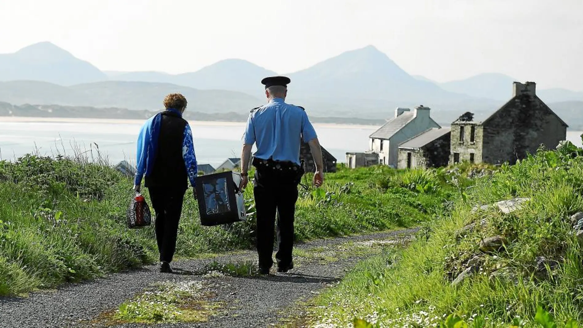 Dos funcionarios transportan una urna en la isla irlandesa de Inishbofin un día antes del referéndum