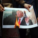 Un grupo de iraníes quema una fotografía del presidente estadounidense, Donald Trump/Efe