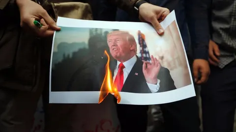 Un grupo de iraníes quema una fotografía del presidente estadounidense, Donald Trump/Efe