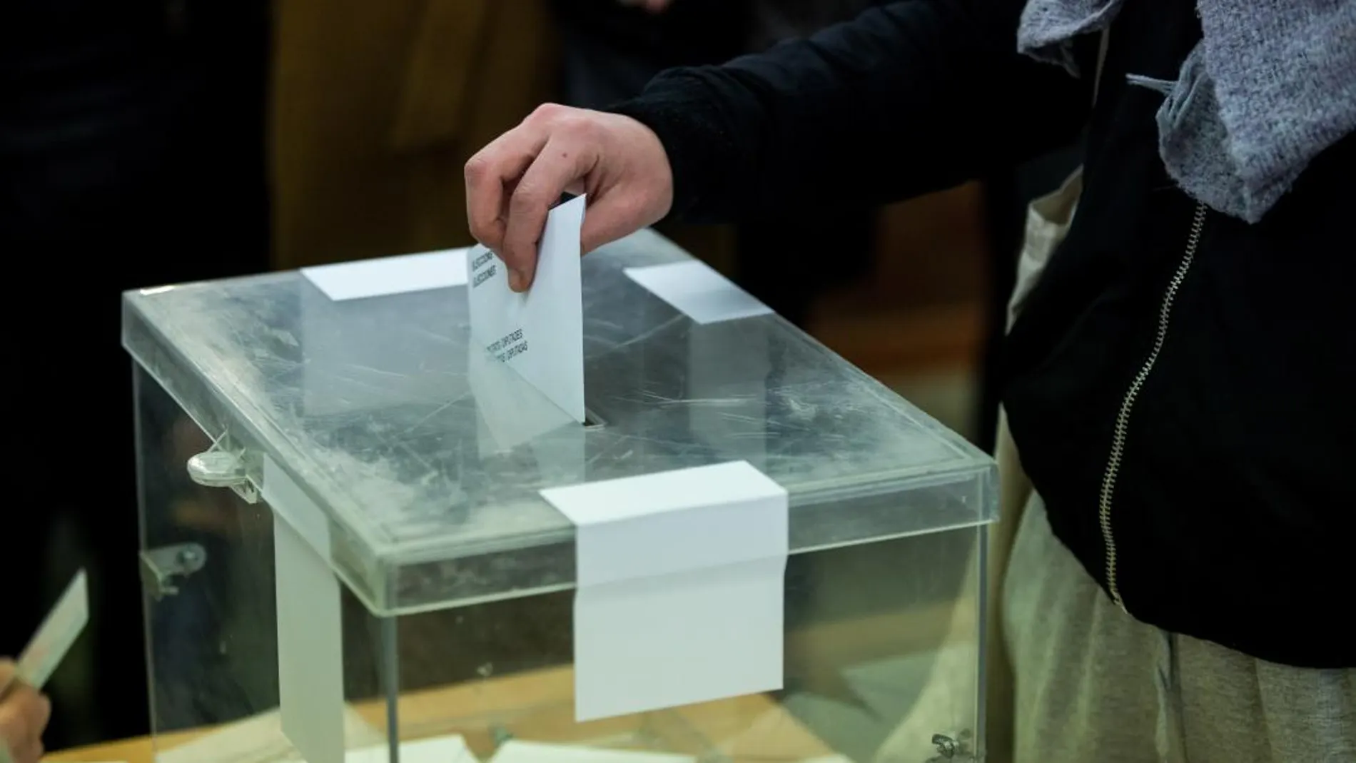 Un ciudadano deposita su voto en la urna de un colegio electoral en Barcelona