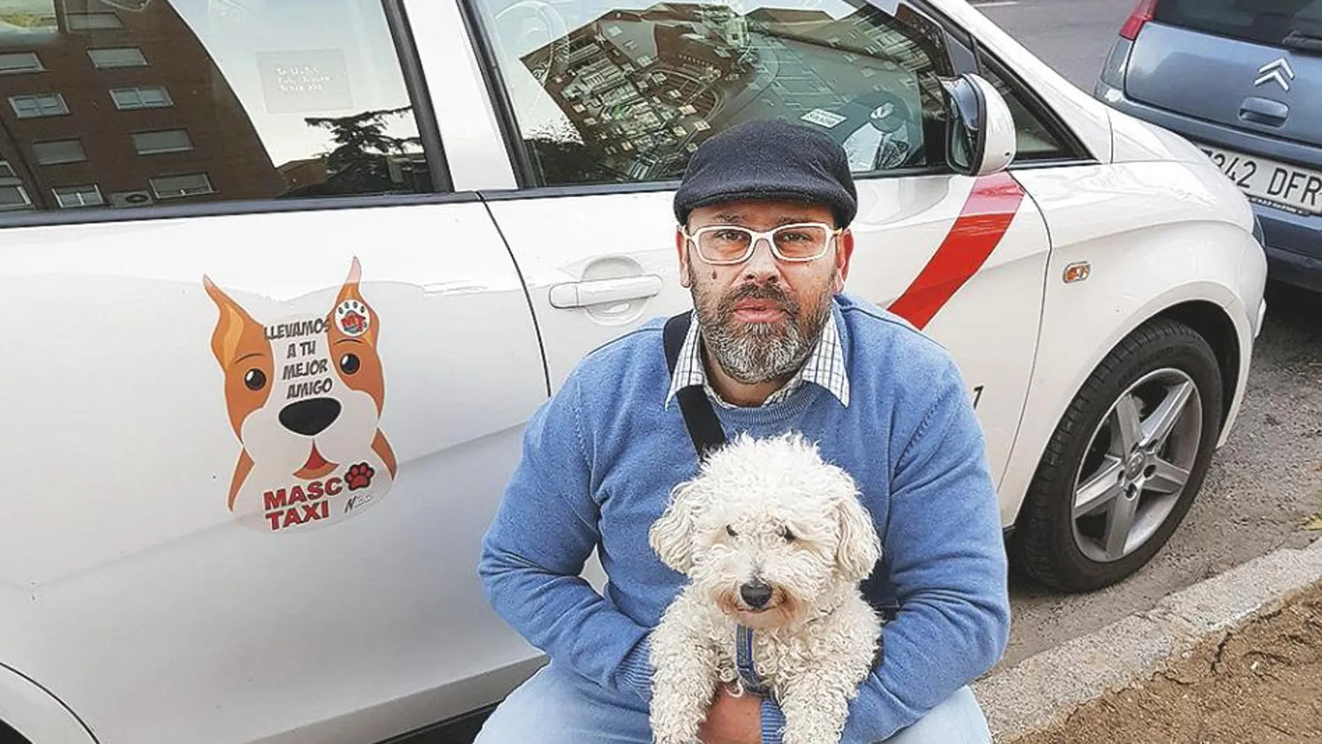 Mario con su perro, junto a su vehículo adaptado para el traslado de mascotas, en Madrid