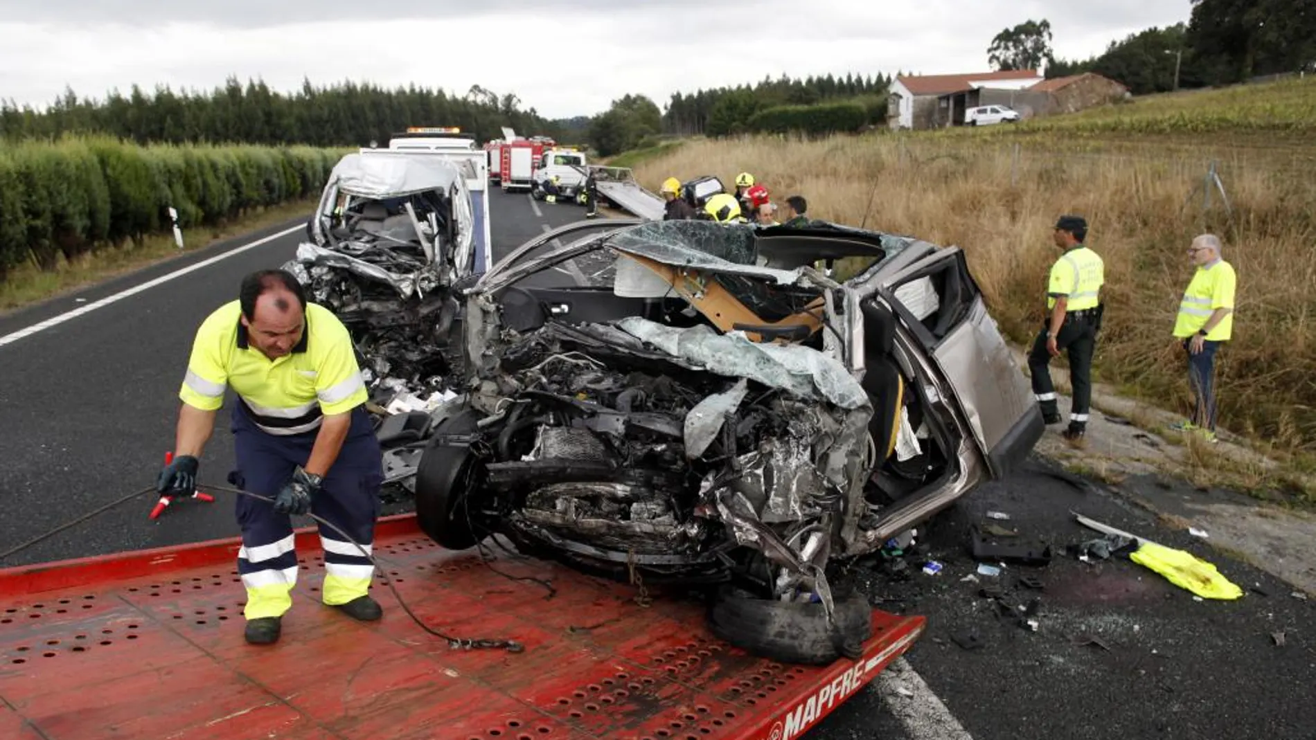 Un operario retira uno de los vehículos siniestrado en un accidente en la A-6 que comunica A Coruña con Guitiriz (Lugo)
