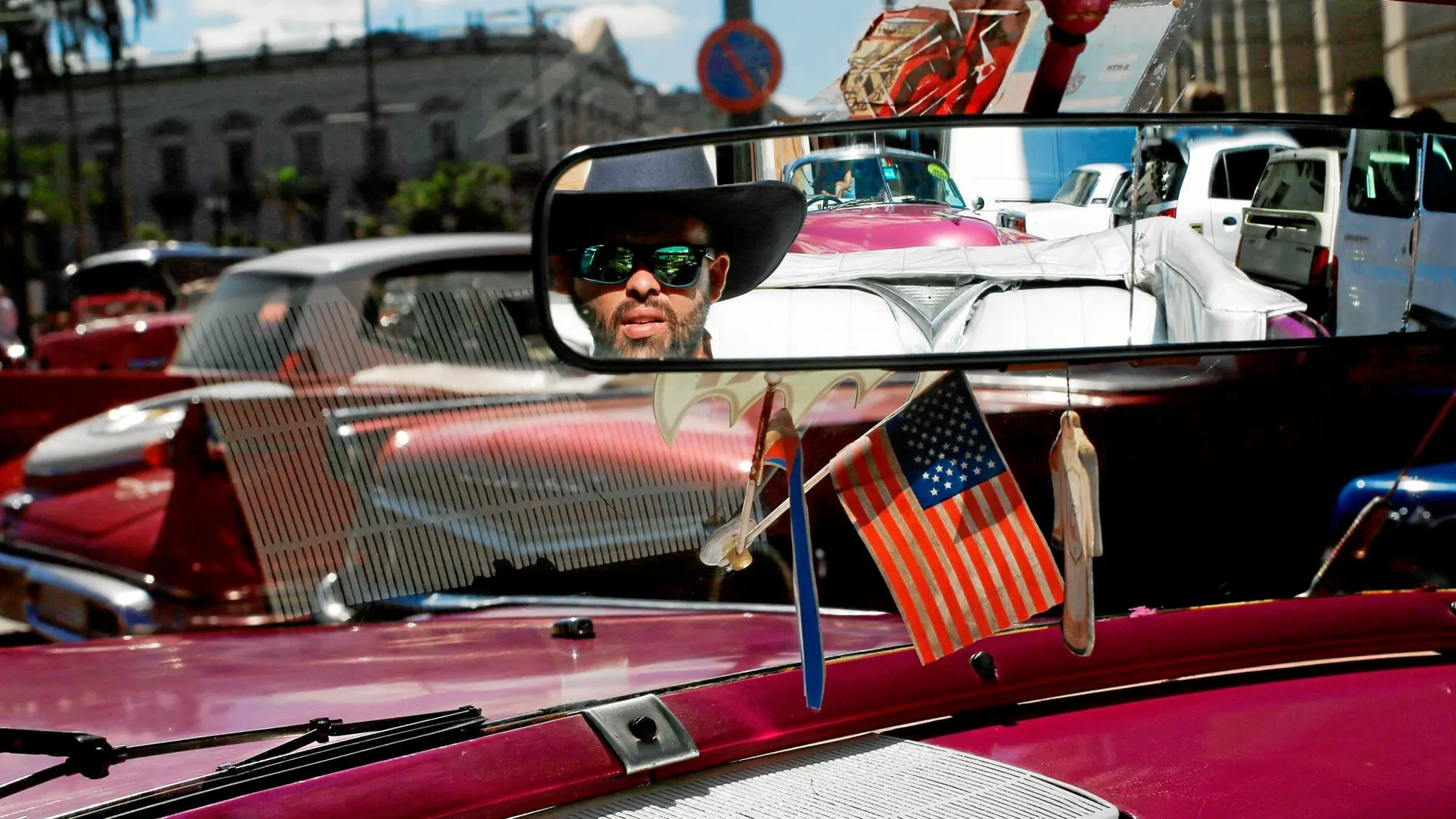 El conductor de un típico coche clásico espera a turistas para darles un paseo por La Habana. Foto: Reuters