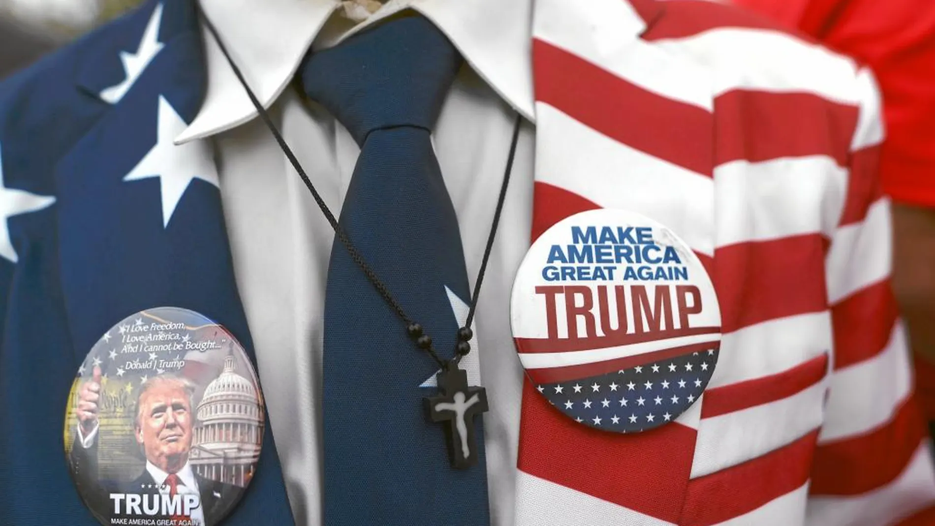 Chapas en la americana de un joven simpatizante de Donald Trump con el lema principal del republicano: «Hagamos grande a América otra vez»