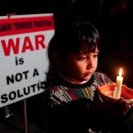 Un niño sostiene una vela en señal de protesta por la crisis entre Pakistán e India/Reuters