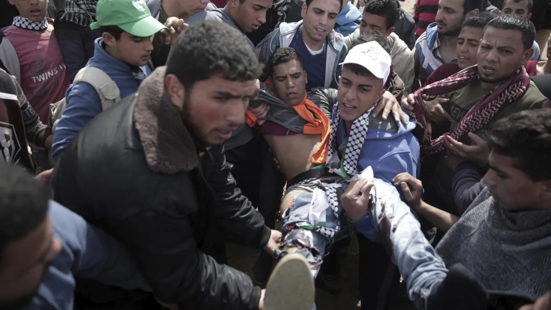Un grupo de palestinos porta a uno de los heridos durante las protestas