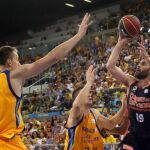 Los jugadores del Herbalife Gran Canaria Anzejs Pasecniksy Xavi Rabaseda y el jugador del Valencia Basket Fernando San Emeterio durante la final de la Supercopa Endesa