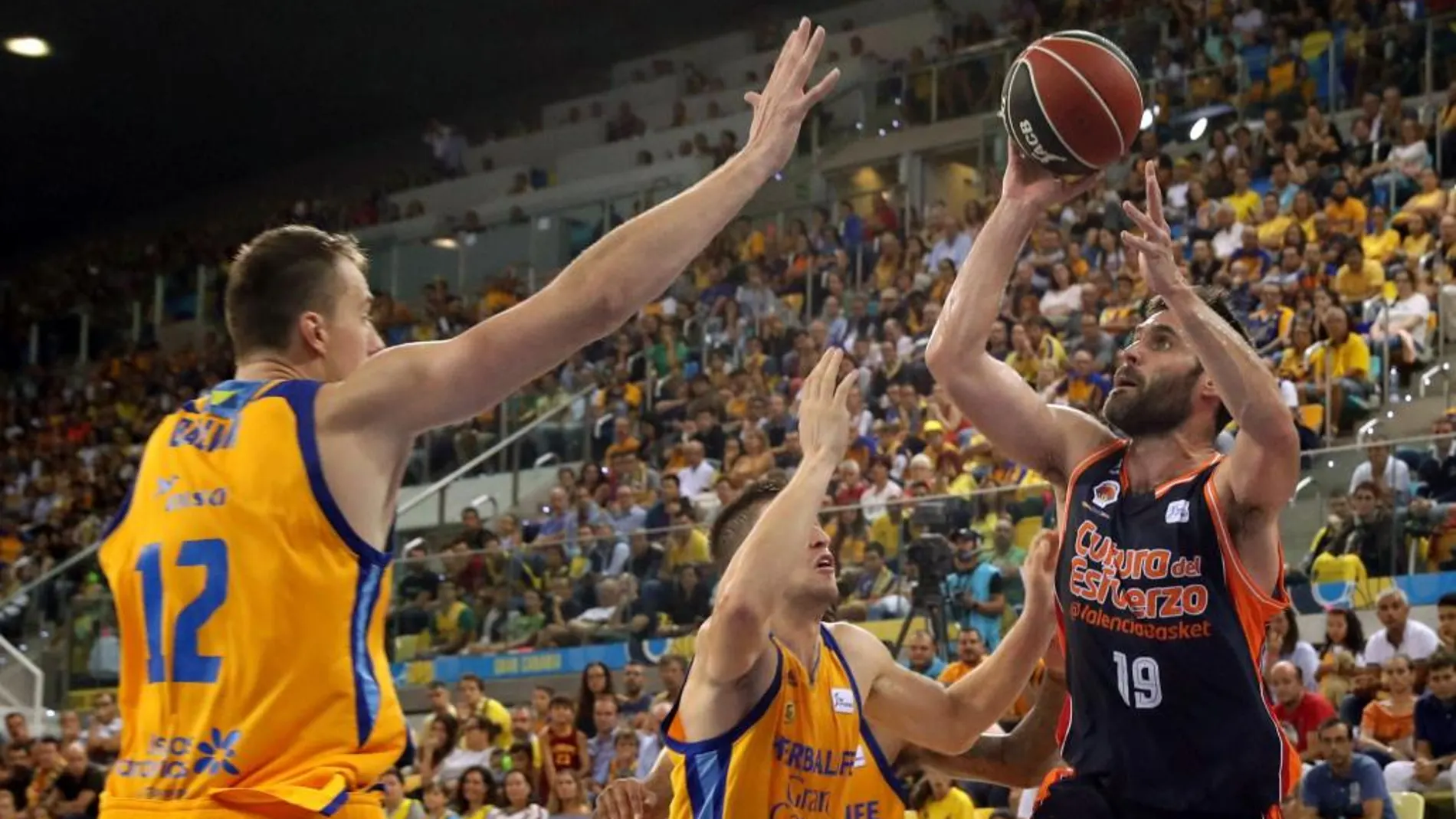 Los jugadores del Herbalife Gran Canaria Anzejs Pasecniksy Xavi Rabaseda y el jugador del Valencia Basket Fernando San Emeterio durante la final de la Supercopa Endesa