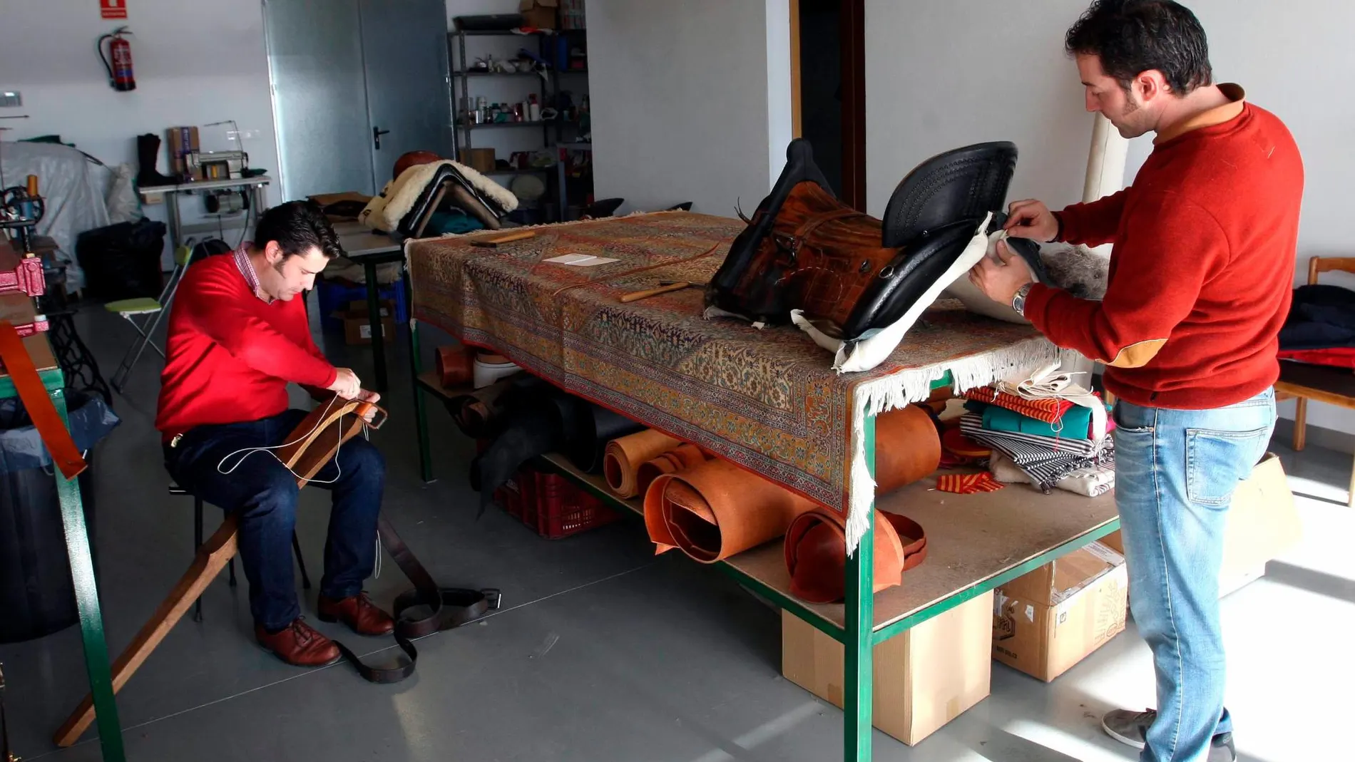 Héctor Díez y Raúl Velasco, autónomos, en pleno proceso de elaboración de sillas de montar en su taller de Portillo