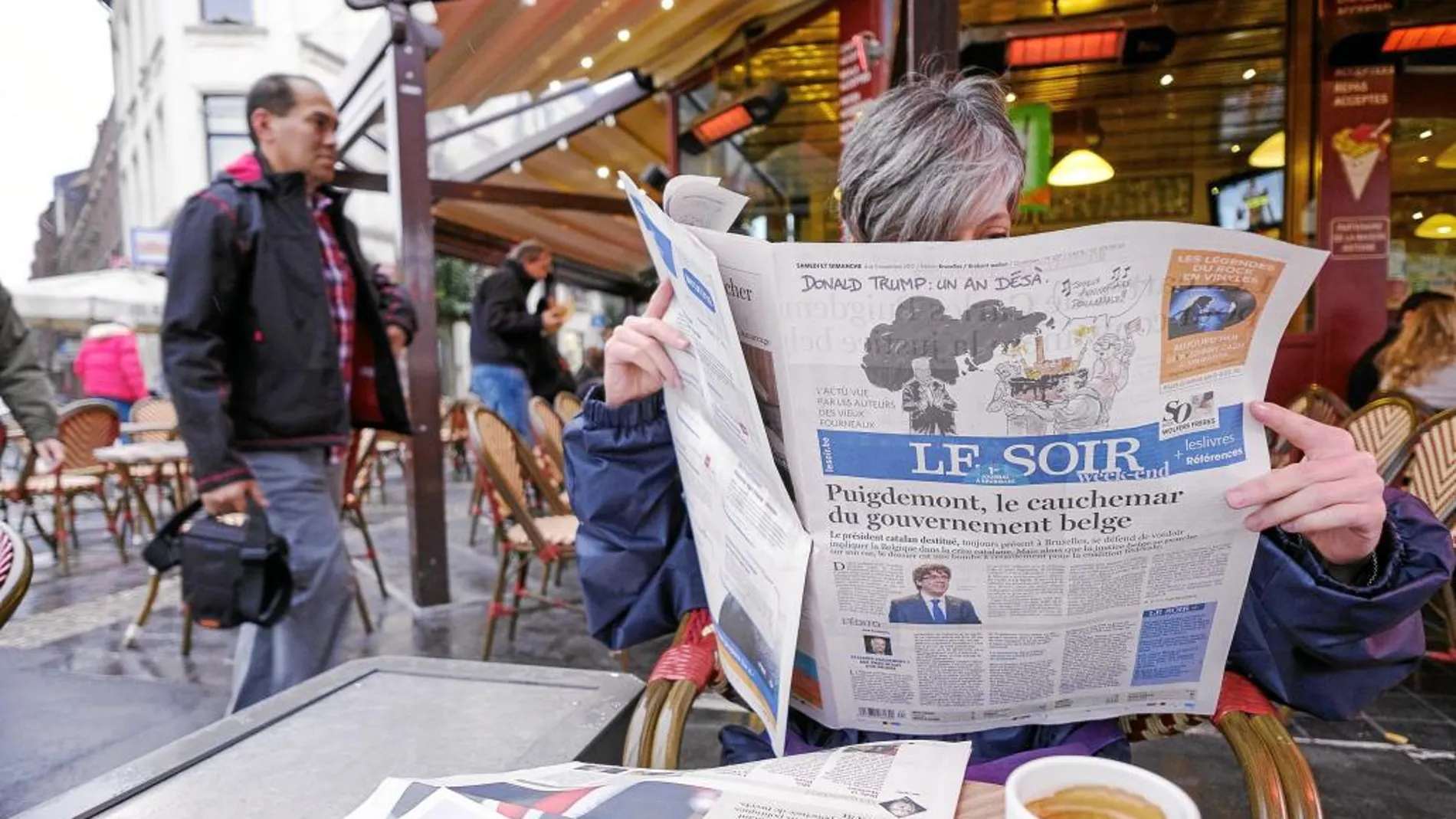 Una persona lee la portada del diario belga «Le Soir», uno de los muchos que llevan a Puigdemont y el problema catalán en portada