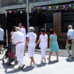 Un grupo de personas pasa por delante del bar de la localidad navarra de Tudela, que estos días vive sus fiestas patronales / Efe