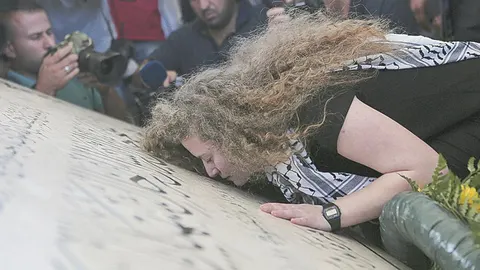 Ahed Tamimi muestra su respeto ante la tumba de Arafat en Ramala poco después de su excarcelación