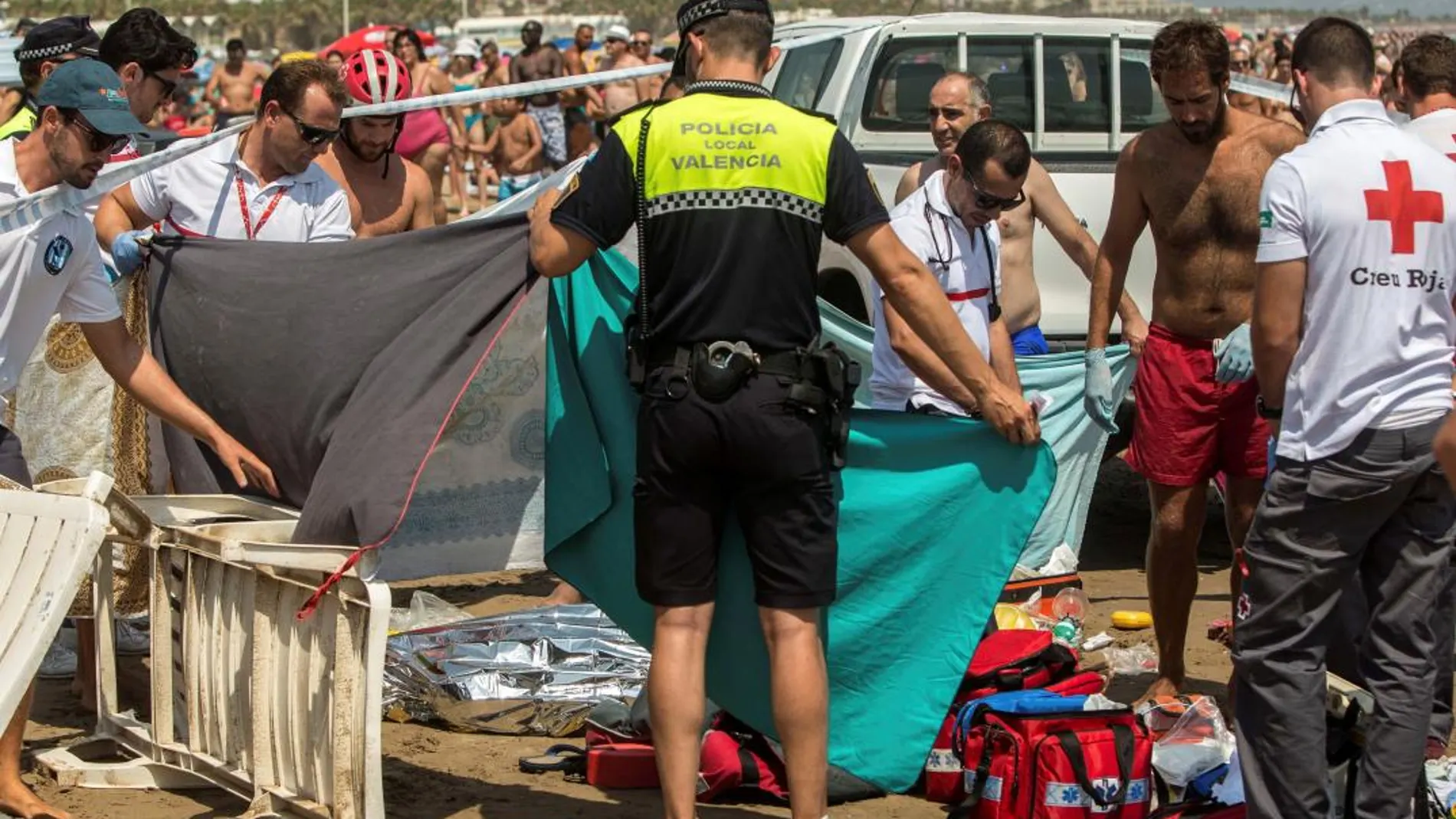 Miembros de la Cruz Roja y Policía Local, junto al cuerpo del joven que se ahogó en aguas de la playa de la Malvarrosa, en Valencia/Efe