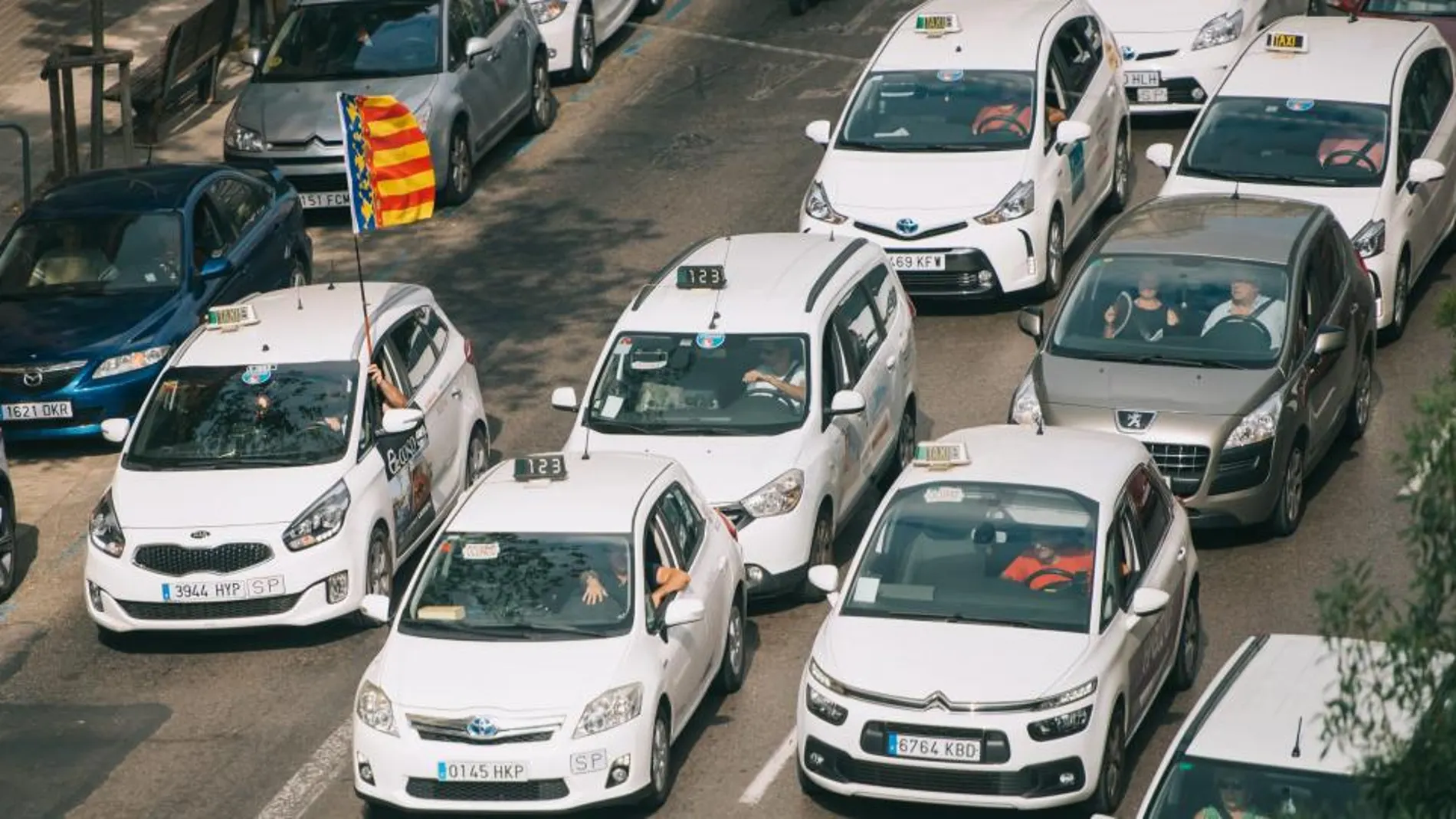 El momento más crítico de la jornada de huelga en la Comunitat se vivió en torno a mediodía: los taxis bloquearon la calle Colón para manifestarse frente a Delegación de Gobierno (KIKE TABERNER)