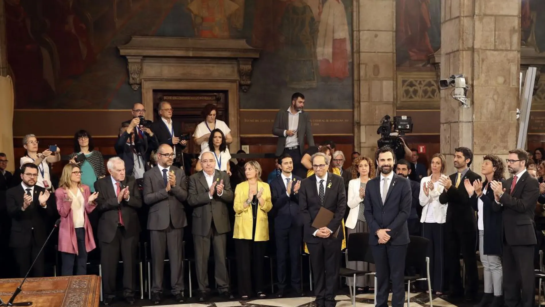 El presidente de la Generalitat, Quim Torra (i), y el del Parlament de Cataluña, Roger Torrent (d), reciben el aplauso de los nuevos consellers del gobierno catalán/Foto: Efe