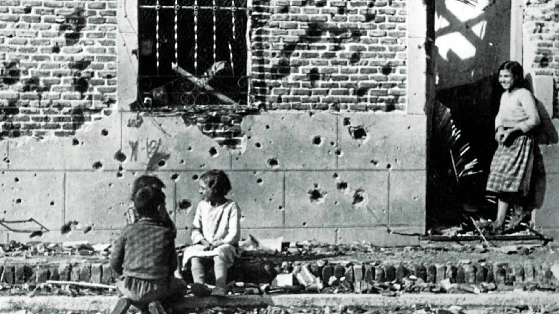 Fotografía de Robert Capa de la casa de la calle Peironcely 10 en la que se observan los restos de metralla en la fachada