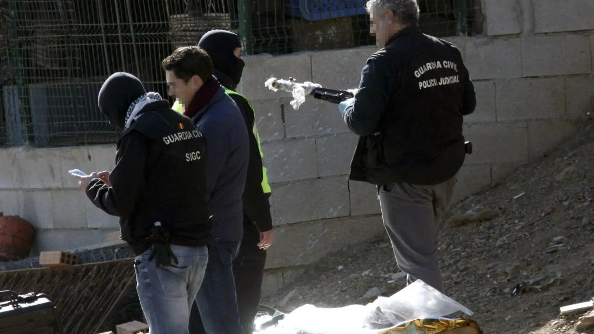 Un agente de la Guardia Civil sostiene un subfusil encontrado en el zulo de los ahora condenados/Efe