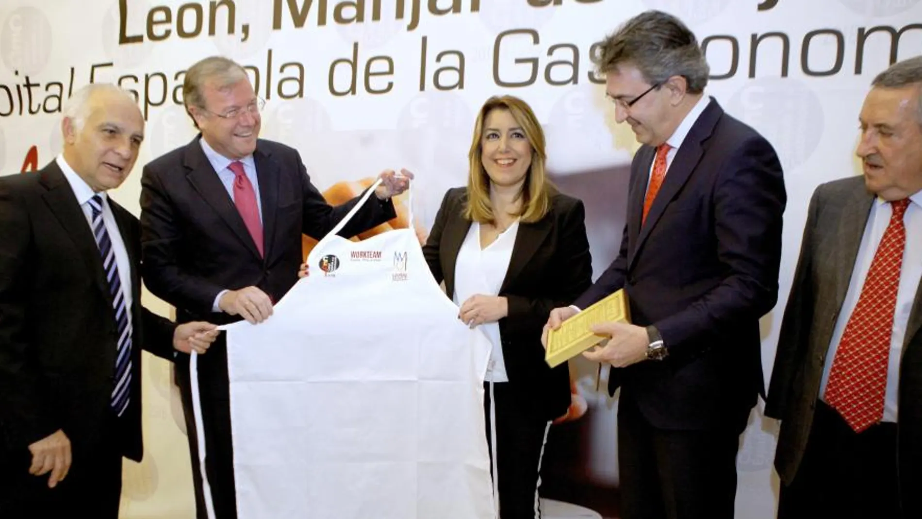 Antonio Silván y Juan Martínez Majo entregan un recetario tradicional leonés a Susana Díaz en la presentación de «León, Manjar de Reyes»