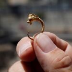 Un arqueólogo israelí sujeta el pendiente de oro del período Helenístico