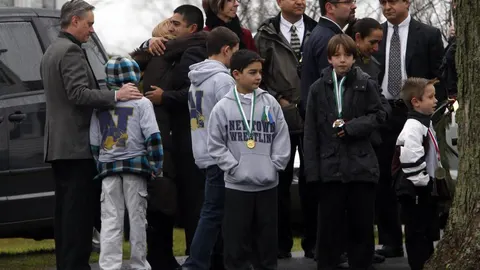 Adultos y niños esperan para entrar en el Honan Funeral Home, donde la familia del niño de seis años Jack Pinto iba a realizar el funeral hoy en Newtown.