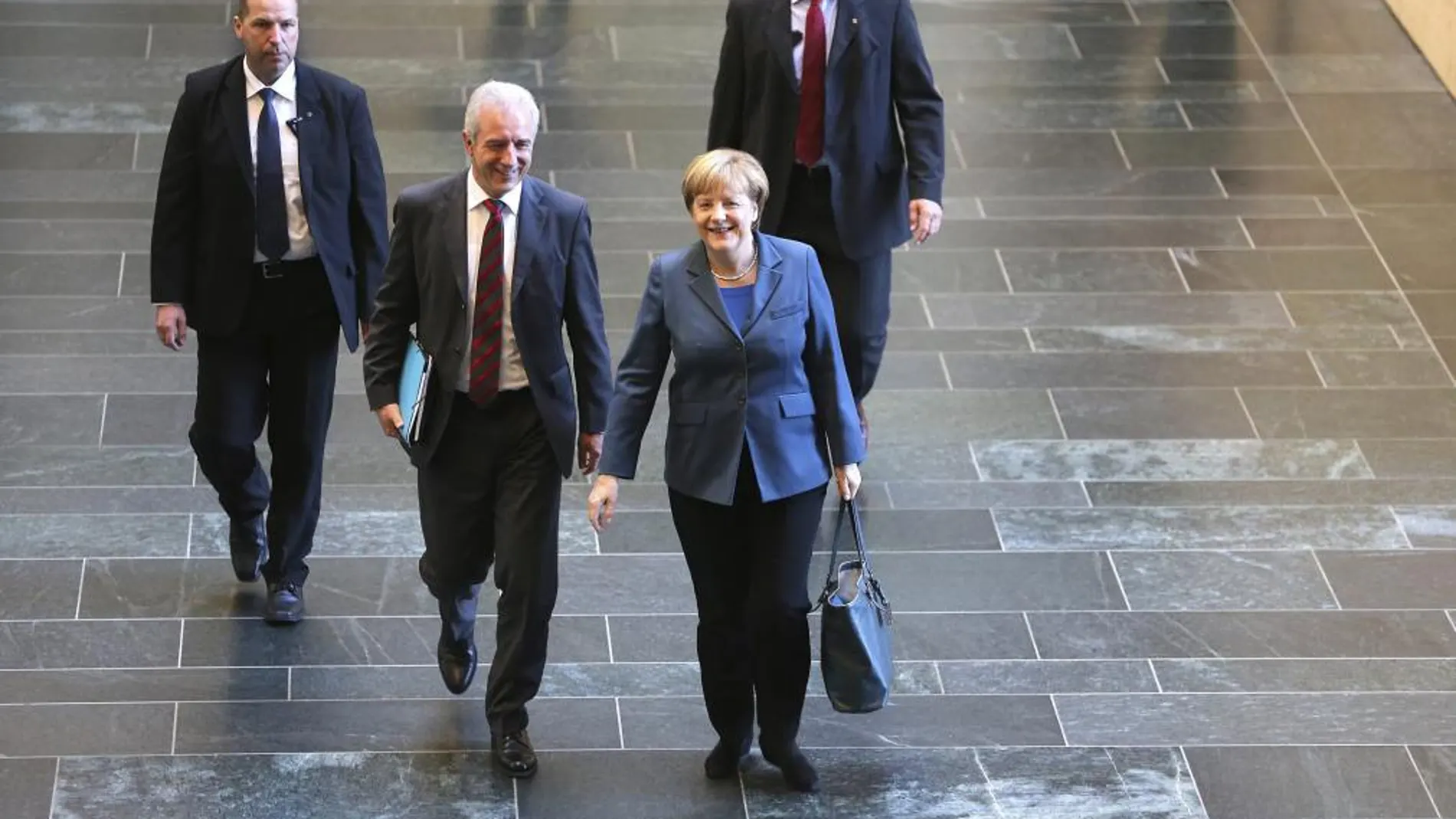 La canciller alemana, Angela Merkel (c-d), y el presidente de Sajonia, Stanislaw Tillich (c-i), a su llegada a una ronda exploratoria con representantes del Partido Socialdemócrata (SPD), en Berlín (Alemania)