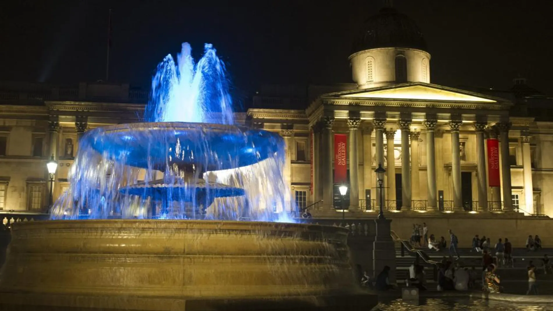 Vista de las fuentes de la Plaza Trafalgar iluminadas de azul para celebrar el nacimiento del hijo del duque y la duquesa de Cambridge, en frente del Palacio de Buckingham