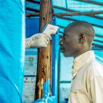 Un ciudadano de Uganda se somete a uno de los controles de temperatura corporal que se han impuesto tras el caso del joven infectado de ébola en el país africano / Ap