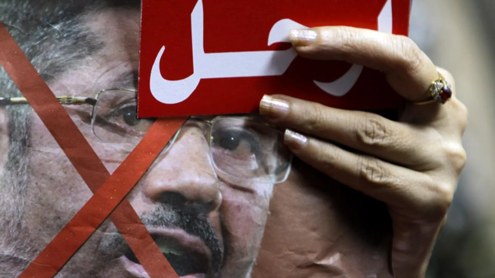 Un detractor de Mursi muesta una tarjeta roja en la que insta al presidente egipcio a marcharse
