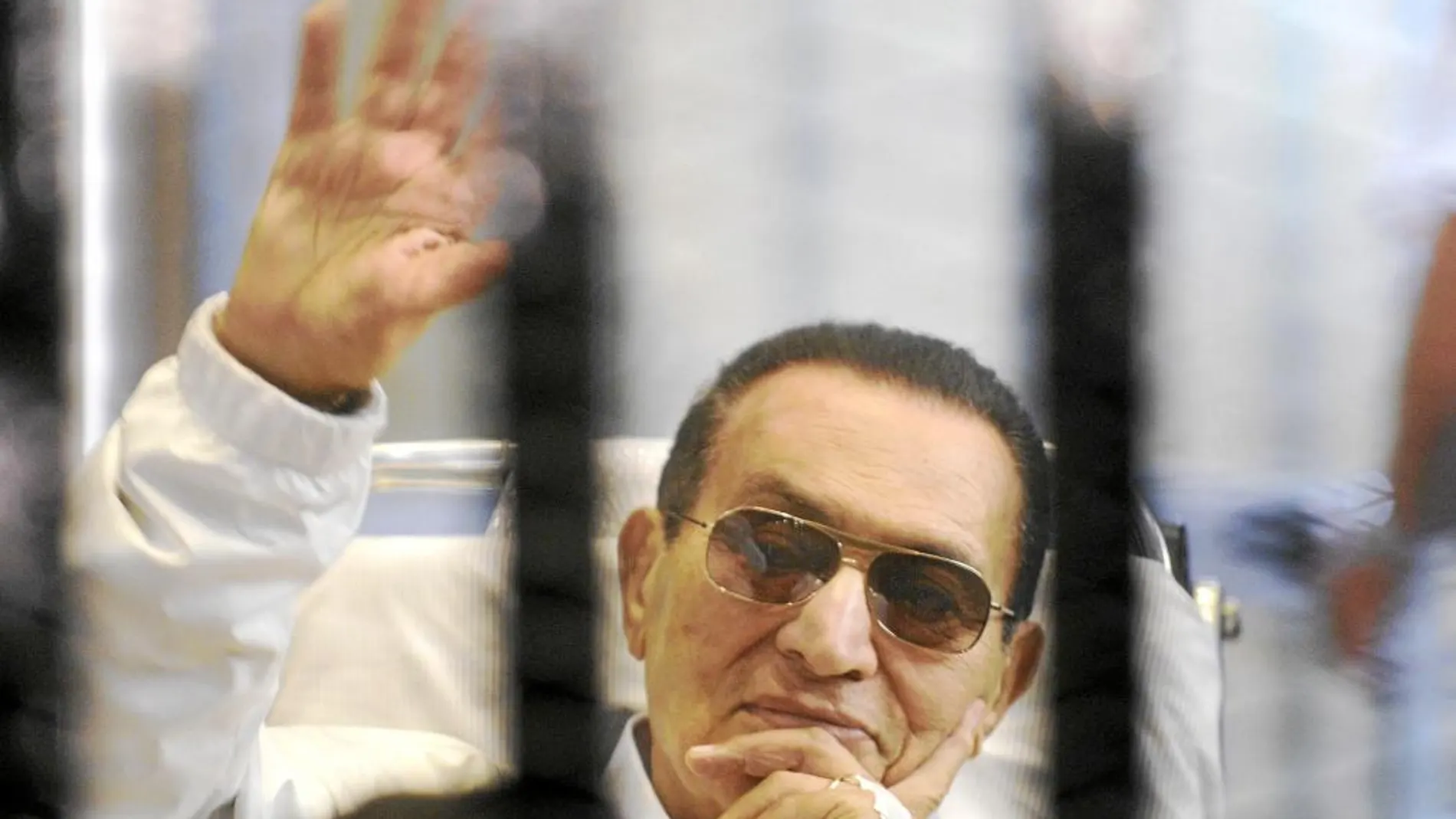 Hosni Mubarak saluda a la cámara durante un juicio
