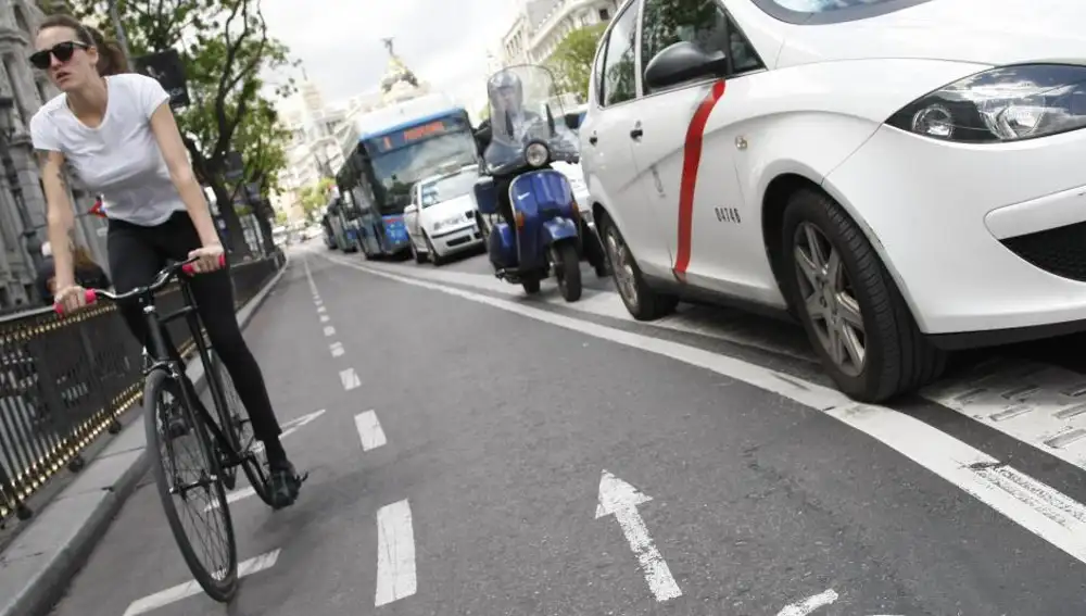 Una ciclista circula sin casco por el carril bici de la calle de Alcalá de Madrid