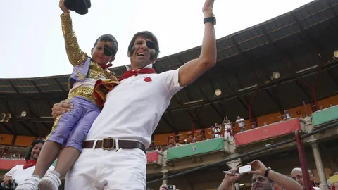 Padilla saluda a la afición junto a uno de los niños que presenció la clase