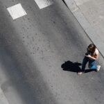 Una joven cruza la calle por lugar indebido mientras consulta el móvil / David Jar