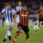 Iñigo Martínez, de la Real Sociedad, pelea por un balón con Luiz Adriano, del Shakhtar Donetsk.