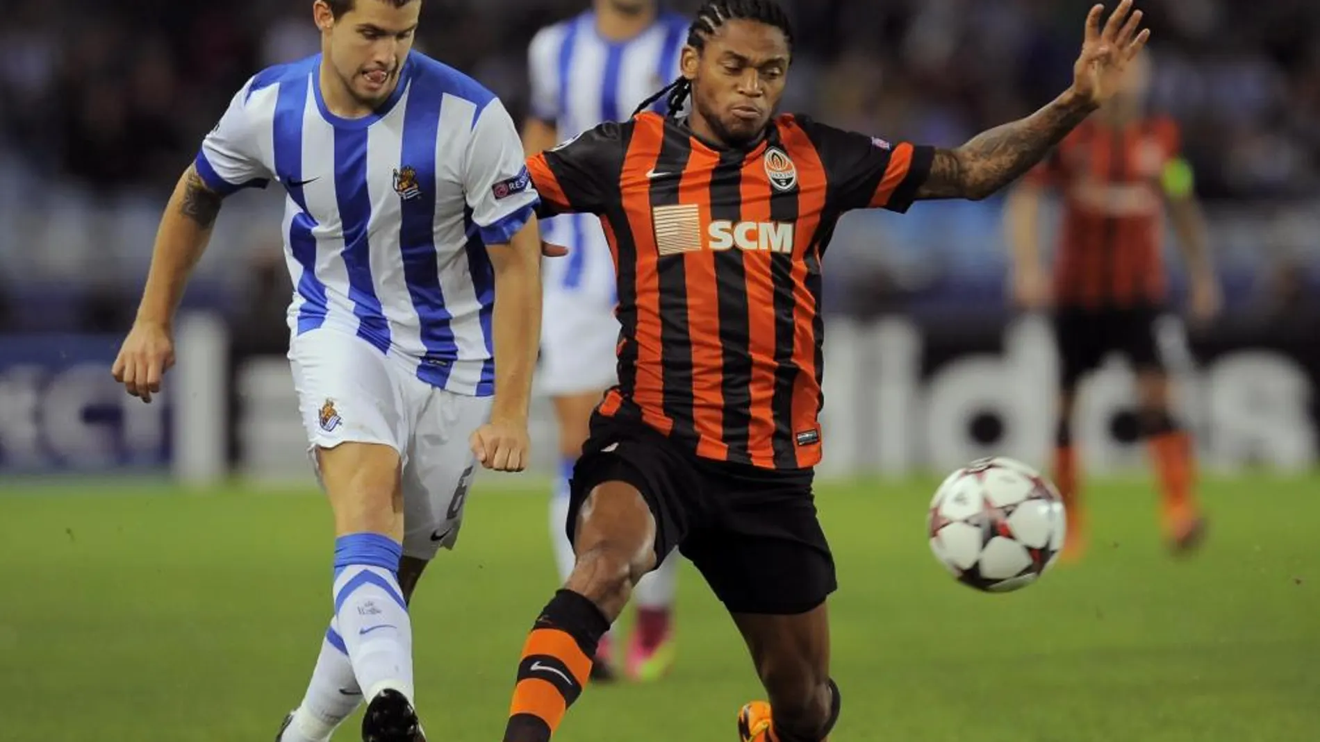 Iñigo Martínez, de la Real Sociedad, pelea por un balón con Luiz Adriano, del Shakhtar Donetsk.