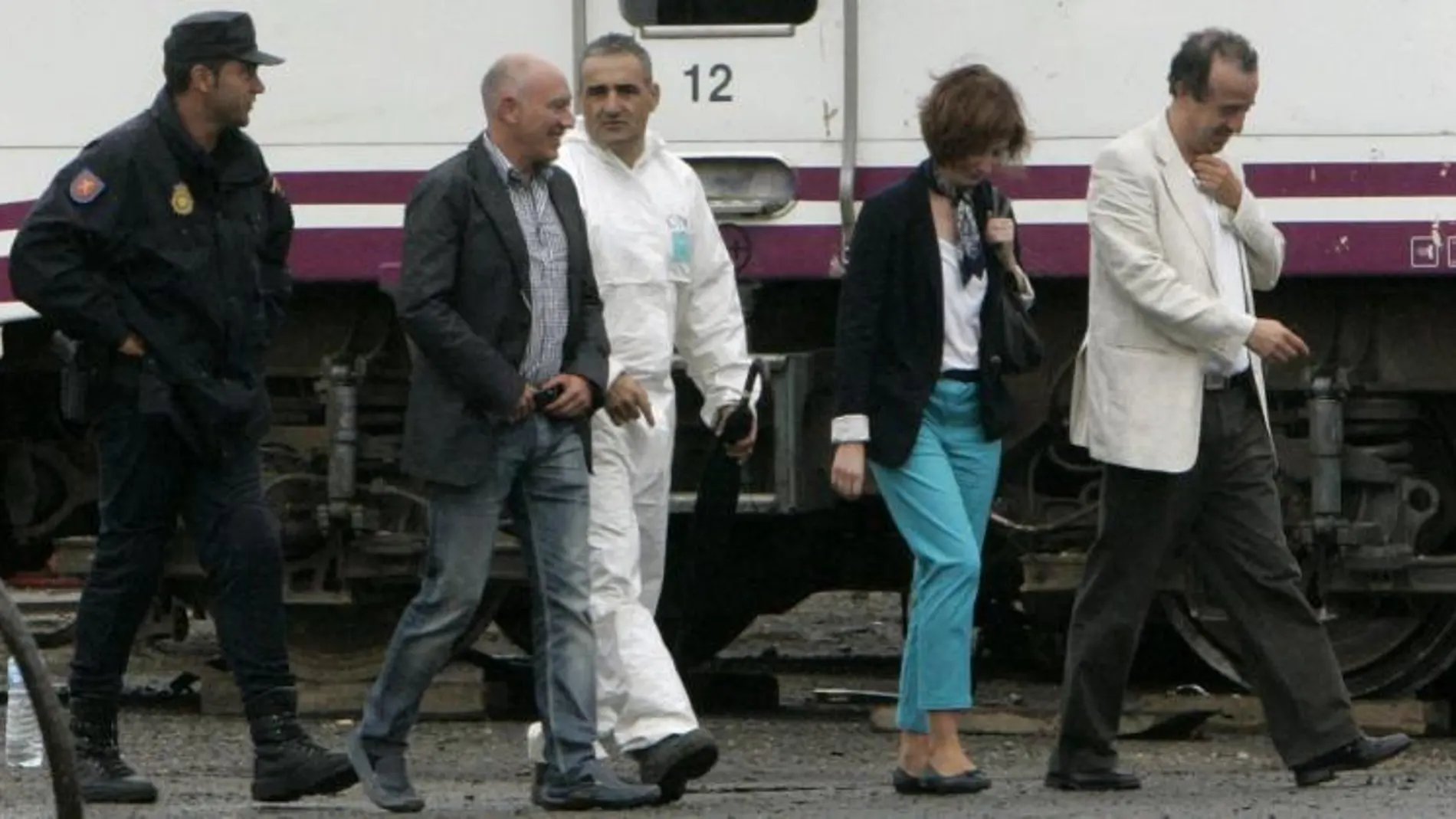 El juez encargado de investigar el accidente del Alvia, Luis Aláez (2i), acompañado por otros miembros del juzgado, durante su visita al lugar donde se custodia e investiga los vagones y máquinas del tren accidentado.