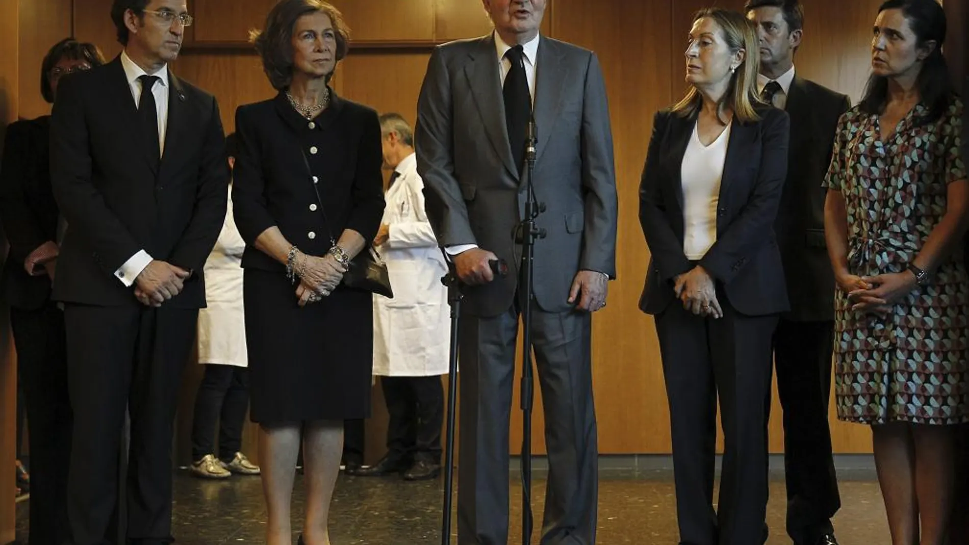 El rey Juan Carlos, durante las declaraciones que ha realizado a la prensa, ante la reina Sofía; la ministra de Fomento, Ana Pastor (3d); el presidente de la Xunta, Alberto Núñez Feijóo (i); la presidenta del Parlamento gallego, Pilar Rojo (d), y el delegado del Gobierno en Galicia, Samuel Juárez