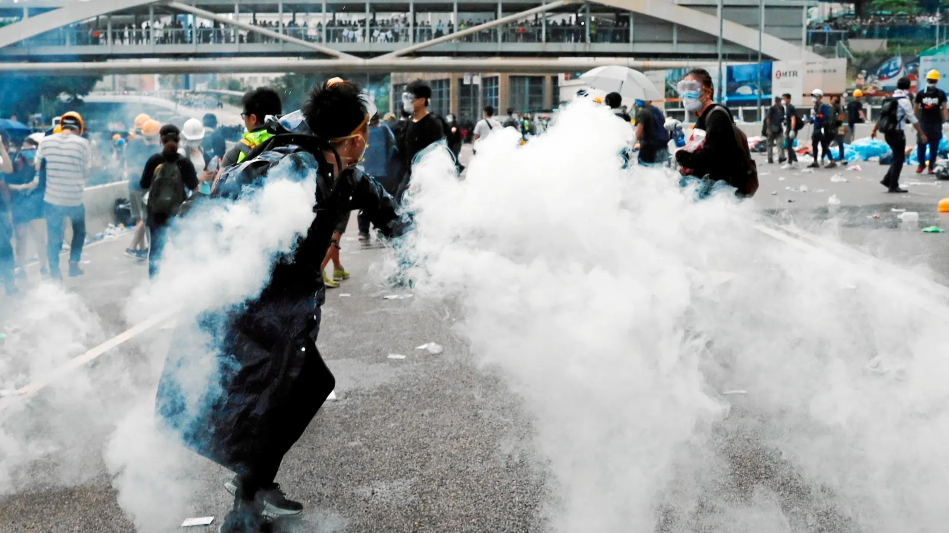 Un manifestante devuelve una lata de gas lacrimógeno.