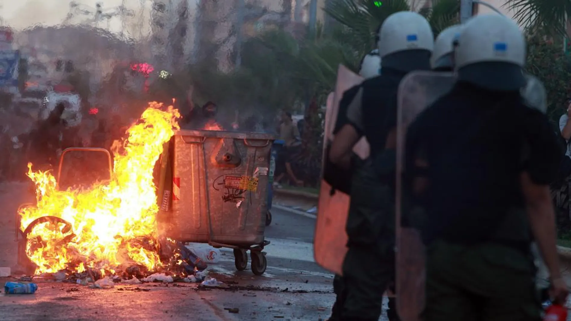 Manifestantes antifascistas chocan con policía antidisturbios en el exterior de una comisaría de policía en Keratsini, Atenas, Grecia.