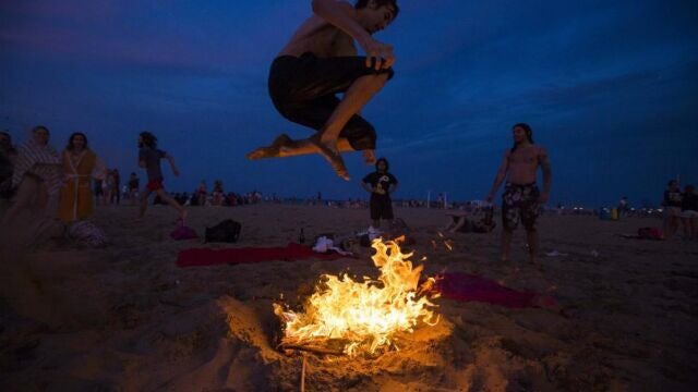 Un joven salta una hoguera durante la noche de San Juan en la playa de la Malvarrosa de Valencia, en una imagen de archivo