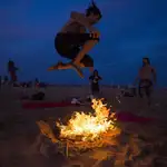 Un joven salta una hoguera durante la noche de San Juan en la playa de la Malvarrosa de Valencia, en una imagen de archivo