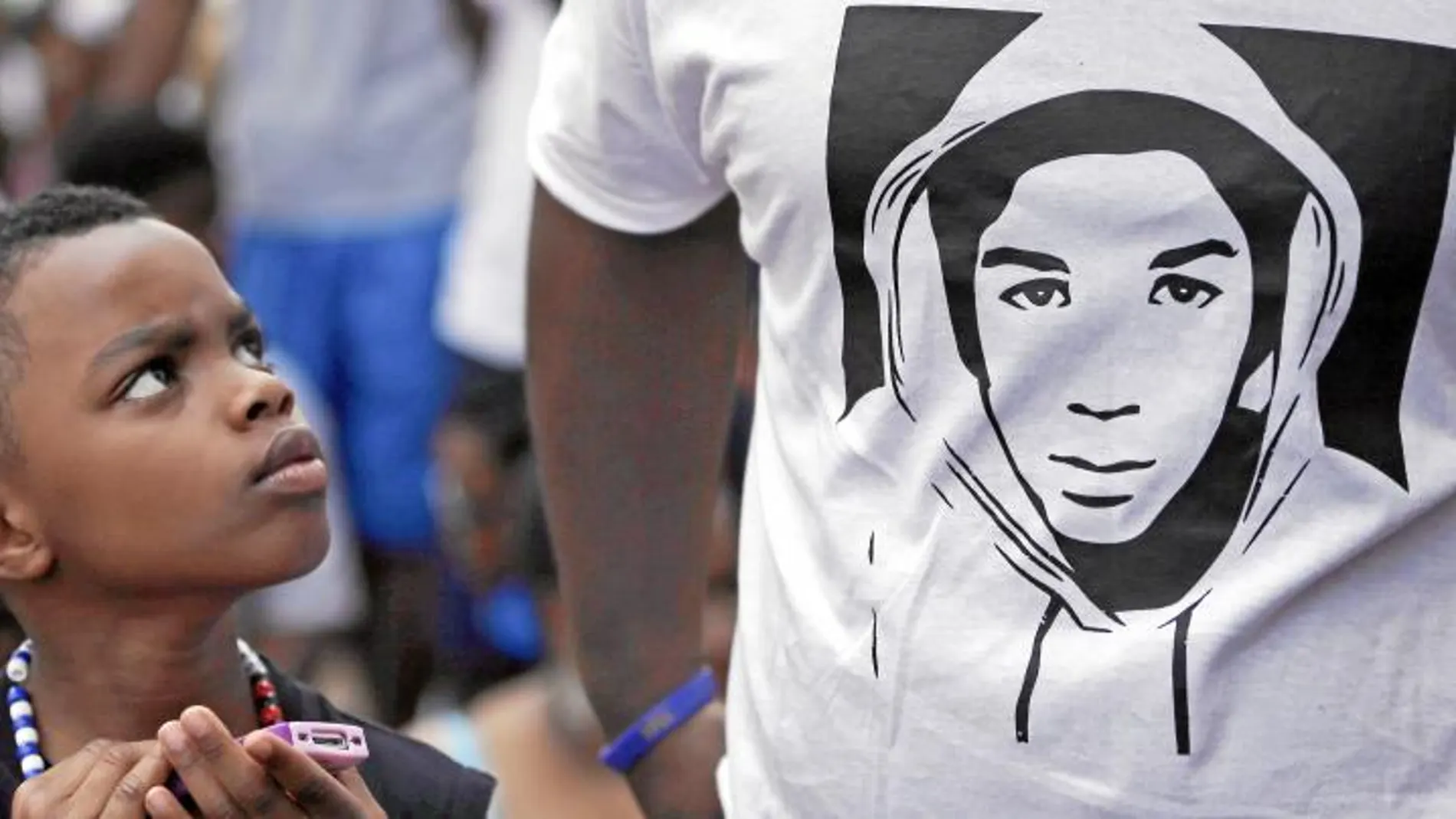 Un niño observa la camiseta con la imagen de Trayvon en una de las concentraciones, ayer