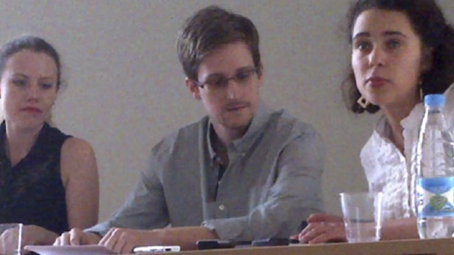 Snowden, en el centro, en una fotografía facilitada por la organización Human Rights Watch (HRW) que muestra al exanalista de la CIA durante una rueda de prensa en el aeropuerto moscovita de Sheremetyevo, el pasado 12 de julio de 2013.