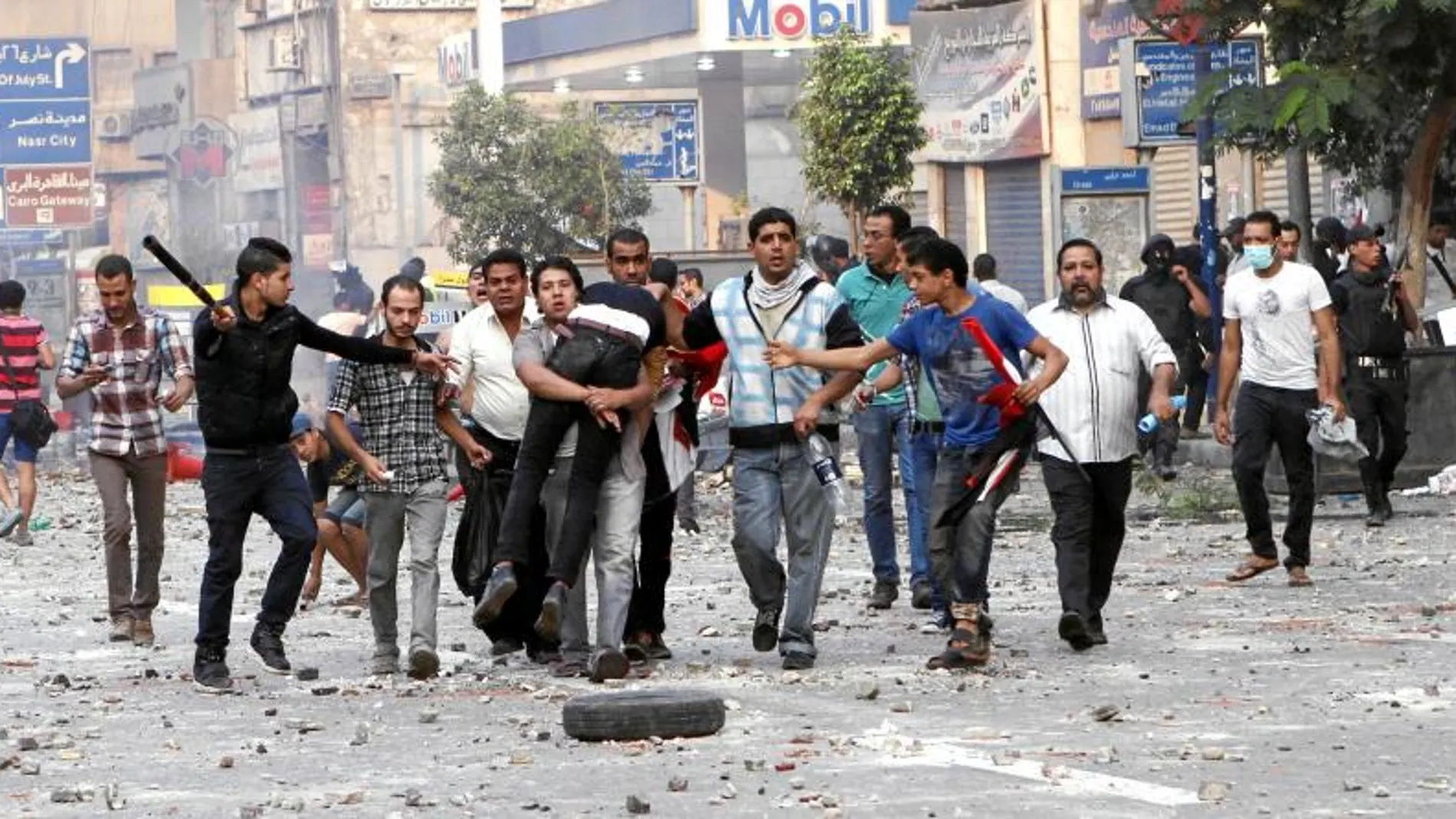 Un policía egipcio golpea a un grupo de seguidores de Mursi, en la Plaza Ramsés, en El Cairo